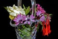 Close up image of a Glass Vase full of mixed colourful fresh flowers. Isolated on black
