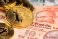 Close up image of gplden Bitcoin with Indian Rupee banknotes. Bitcoin on India Rupee Cryptocurrency against money from India Royalty Free Stock Photo