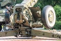 A close-up image of a green tank and a gray artillery gun on display in an open space, with even lighting a Royalty Free Stock Photo