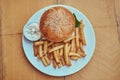 Close-up image of a hamburger with French fries and spicy sauce on a white plate. Unhealthy food concept Royalty Free Stock Photo