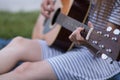 Close up image of a woman's hand playing the guitar by the lake during summer Royalty Free Stock Photo