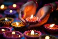 Close-up image of hands lighting Diwali diyas, symbolizing the victory of light over darkness