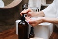 Close up image of hands of a mature woman pumping an eco soap from a bottle