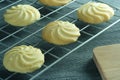 Close up image homemade butter cookies put on wire rack with wooden tray on the table.