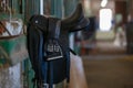 Close up image of horse riding saddle hanging in the stable