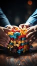 Close-up image of human hands assembling colorful puzzle on wooden table, vertical