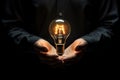 Close up image of human hands holding light bulb with idea concept, Conceptual image of lightbulb in hand against Black background Royalty Free Stock Photo