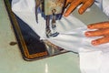 Indian woman hands stitching white cloth with the help of a sewing machine