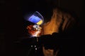 Close-up image of industrial worker at the factory welding steel structure on black background. Royalty Free Stock Photo