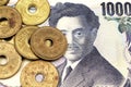 A close up image image of Japanese five yen coins on a 1000 yen note