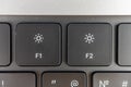 Close-up image of a keyboard with focus on function keys F1 and F2, featuring a light bulb or sun icon between them Royalty Free Stock Photo