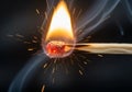 A close-up image of a lit match shows the ignition process. The match head, composed of red Royalty Free Stock Photo