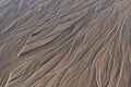 Close up image looking down on patterns in a wet sandy beach, showing textures, shapes and ripples Royalty Free Stock Photo