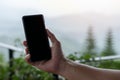 Close-up image of male hands holding and showing a smartphone at balcony of cafe Royalty Free Stock Photo