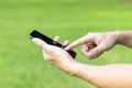 Close-up image of male hands using black smartphone in park Royalty Free Stock Photo