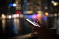 Close-up of male hands using smartphone at night on city shopping street. Searching or social networks concept Royalty Free Stock Photo