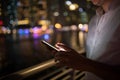 Close-up of male hands using smartphone at night on city shopping street. Searching or social networks concept Royalty Free Stock Photo