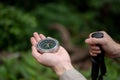 Close-up image of a male hiker holding a compass while hiking in the forrest alone