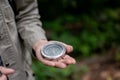 Close-up image of a male hiker holding a compass while hiking in the forrest alone