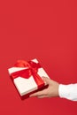 Close-up image of man hands holding gift box over red background. Christmas and New Year concept. Royalty Free Stock Photo