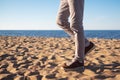 Close up image of man legs walking alone sandy beach with blue ocean and white sand, Royalty Free Stock Photo