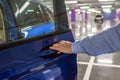 Male hand opening a car door in an underground parking lot. Royalty Free Stock Photo