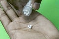 Close-up image of manÃ¢â¬â¢s extracting homeopathic pills from medicine bottle on hand Royalty Free Stock Photo
