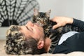 Close up image of man sleeping with his tabby cat on bed. Cat is posing above human. Love and care for animals concept Royalty Free Stock Photo