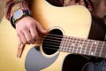 Close up image of man strumming guitar