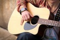 Close up image of man strumming guitar