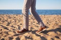 Close up image of man walking alone sandy beach with blue ocean and white sand Royalty Free Stock Photo