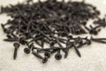 Close-up image of many small black screws on concrete background Royalty Free Stock Photo