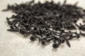 Close-up image of many small black screws on concrete background Royalty Free Stock Photo