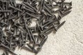 Close-up image of many small black screws on concrete background Royalty Free Stock Photo