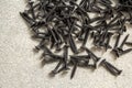 Close-up image of many small black screws on concrete background Royalty Free Stock Photo