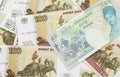 A UK five pound note on a background of Russian one hundred ruble bills