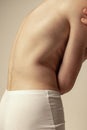 Close-up image of muscular male back isolated over grey studio background. Model posing in underwear. Freckled body Royalty Free Stock Photo