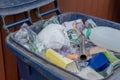 Close-up image on an opened blue plastic recycle bin.