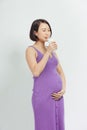 Close-up Image of pregnant woman Holding a glass of fresh milk and touching her belly with hands on white background Royalty Free Stock Photo