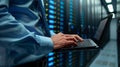 Close-up of a professional using a laptop in a data center server room Royalty Free Stock Photo