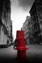 Close-up image of a red fire hydrant standing alone in an urban environment