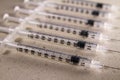 Close-up image of a row of medical syringes with a softer, abstract background.