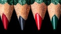 In this close-up image, a sharpened colored pencil with stripes of red and green creates a red stroke against a black background Royalty Free Stock Photo