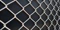 Close-up of a chain-link fence against a dark background.