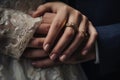 A close-up image showcasing the connection and support between two individuals through the act of holding hands, Wedding rings and Royalty Free Stock Photo