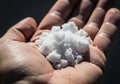 A close-up image shows a hand holding coarse white salt crystals Royalty Free Stock Photo