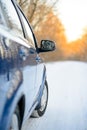 Close up Image of Side Rear-view Mirror on a Car in the Winter Landscape with Evening Sun Royalty Free Stock Photo