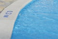 Close up image of sign of depth in meters in swimming pool, shallow pool for children with blue water, no people around, Royalty Free Stock Photo