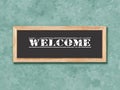 Close up image of a sign on a wall that reads Welcome