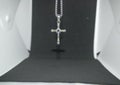 Close-up image of a silver metal christian cross necklace/pendant or silver metal crucifix necklace/pendant hanging